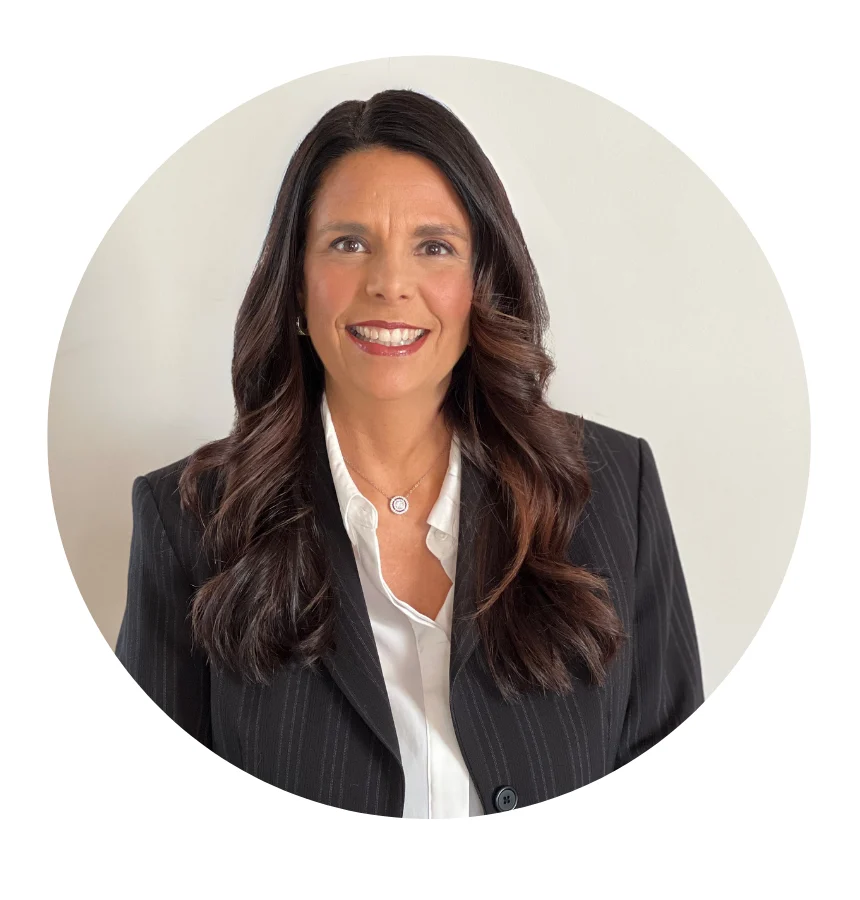 Renee Chaudoin smiling in a black pinstripe jacket and white blouse against a soft neutral background